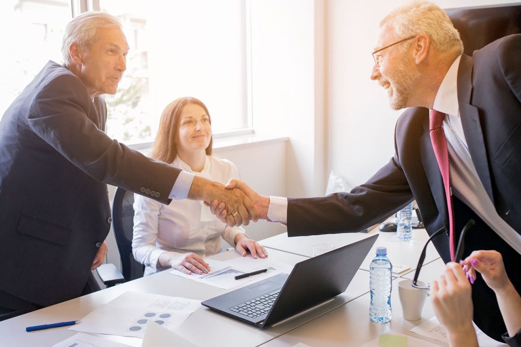 advokat za radno pravo, dva direktora se rukuju u prisustvu advokata